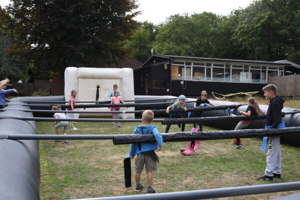 Children playing giant inflatable table football